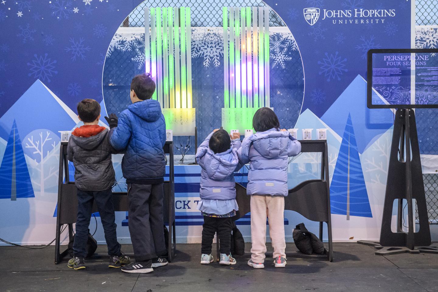 Children play with Persephone, a light and sound organ, at the ice rink in February 2023