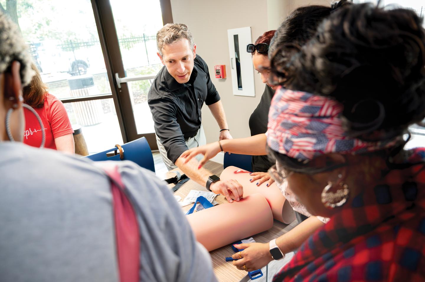 Galiatsatos uses props to instruct community residents on how to stop a bleed