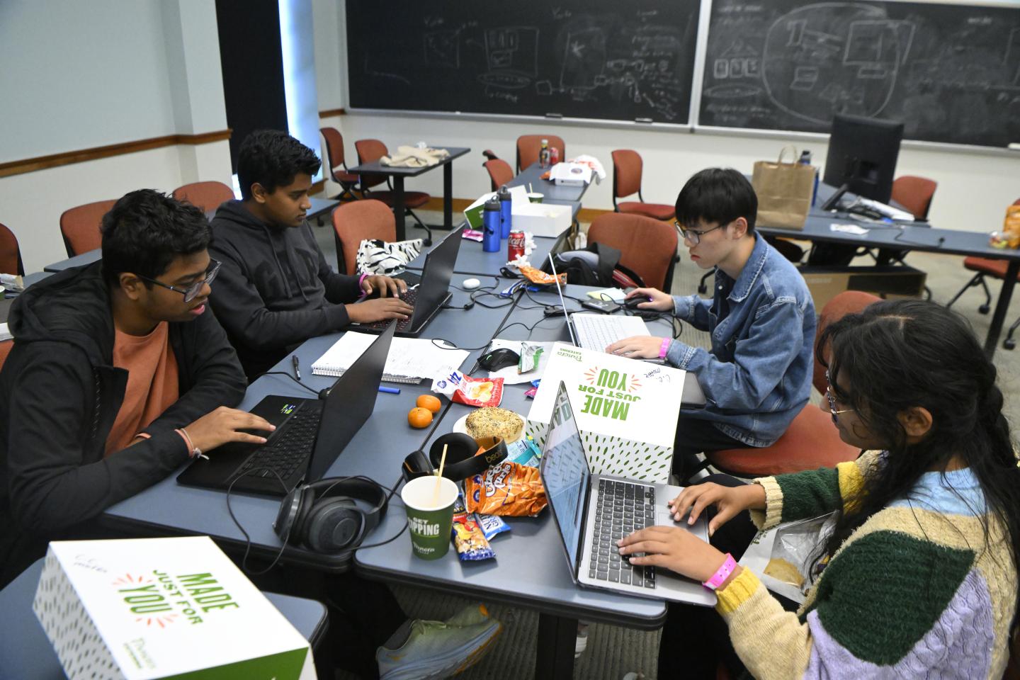HopHacks students with laptops and a tableful of snacks