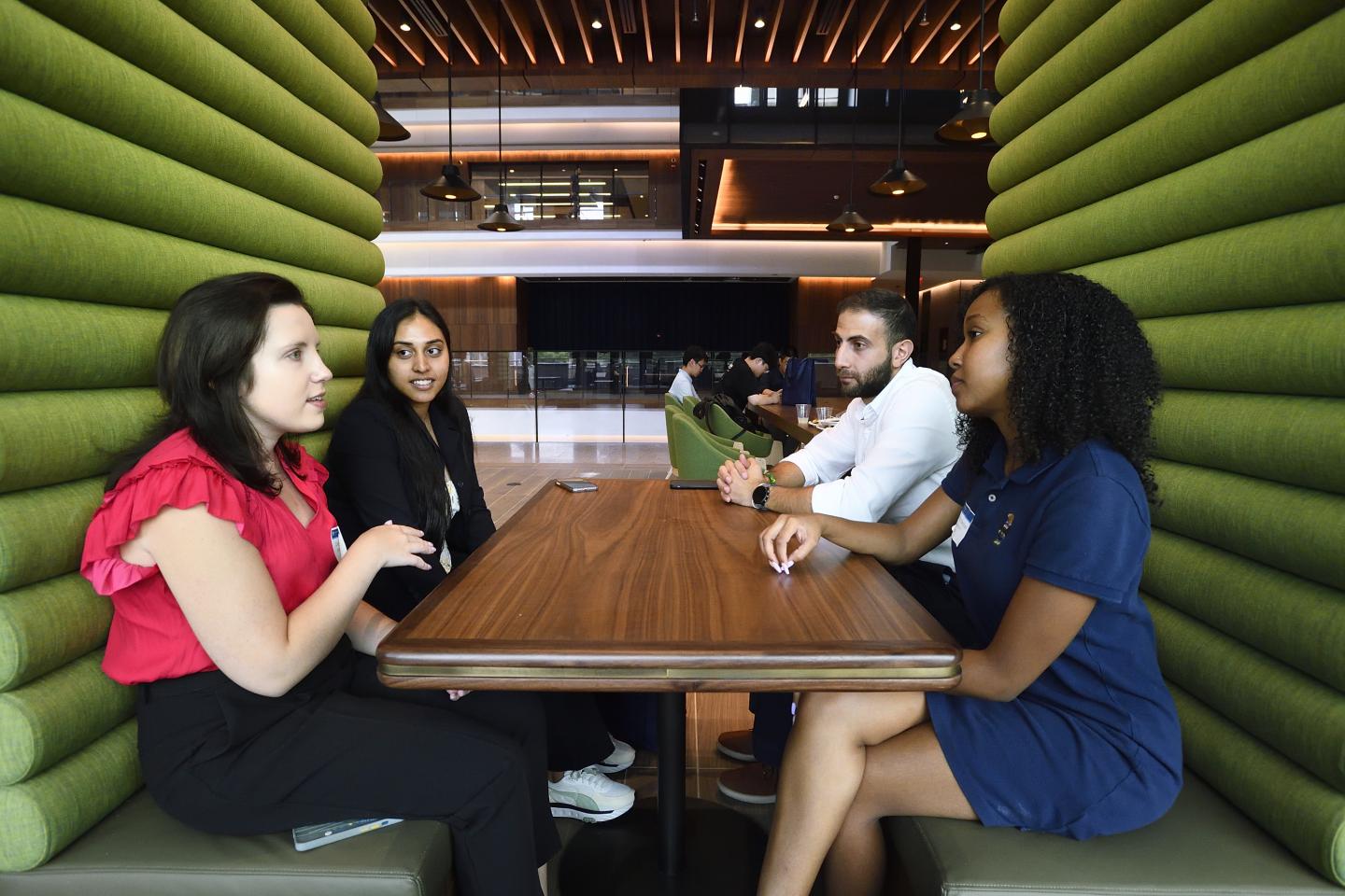 People gathered in a bright green booth inside the Johns Hopkins University Bloomberg Center at 555 Pennsylvania Ave.