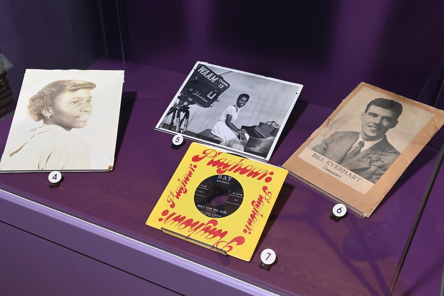 Record singles and photos in a display case in the Ethel's Place exhibition 