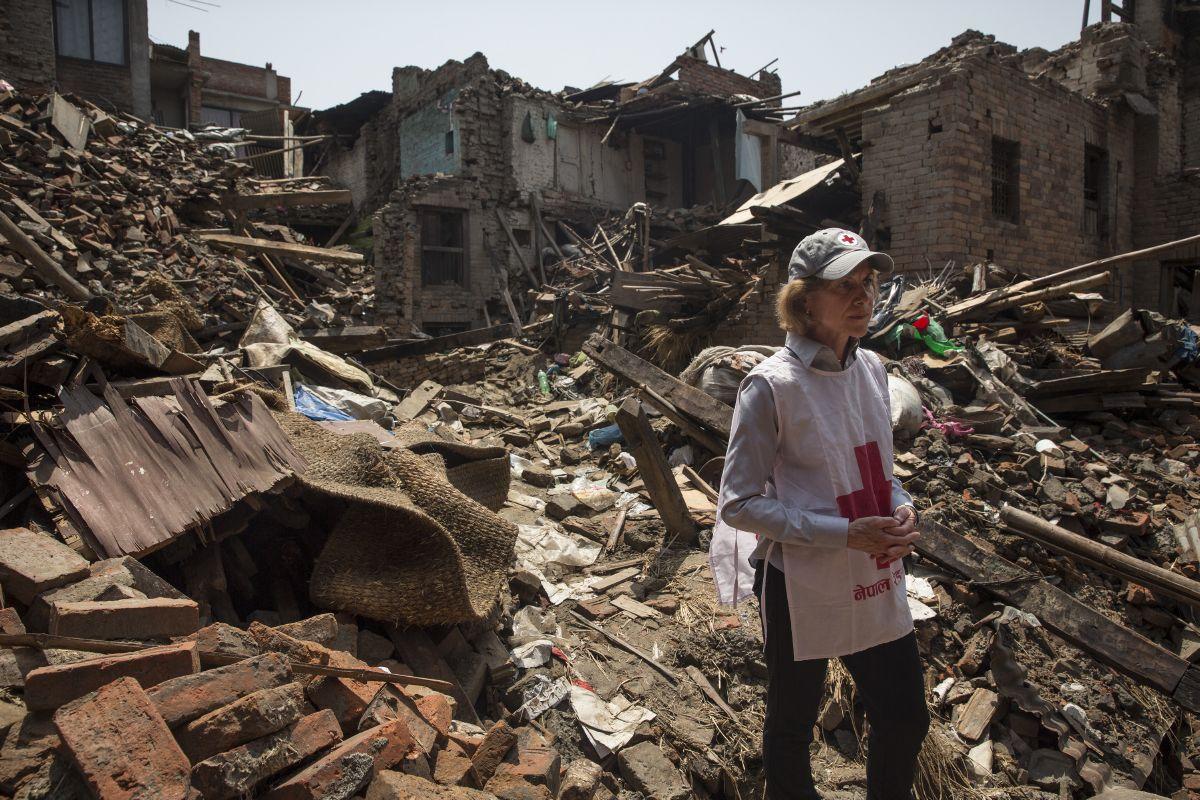 Gail McGovern stands among rubble caused by an earthquake in Nepal