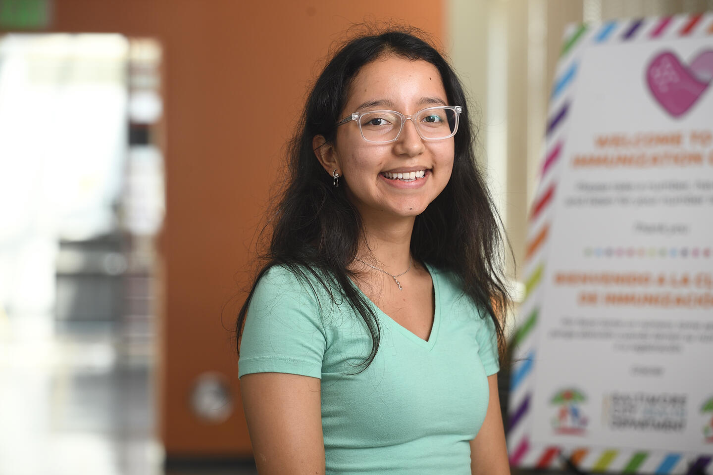 Jennifer Izaguirre Martinez stands next to a sign with a pink heart on it