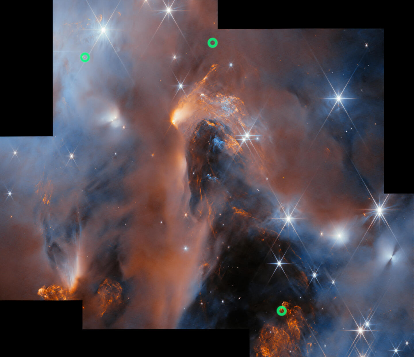 Several images of parts of a nebula in space have been aligned to form a single large image of the nebula. It depicts clouds of gas and dust in blue and orange colours as well as brightly shining stars in various sizes. Around the edge there are some black rectangles where there was no image of that region of space.