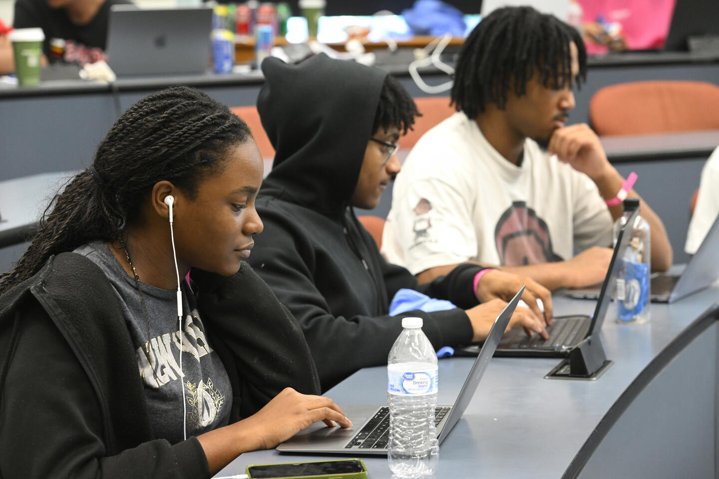 Students in a row looking at laptops during HopHacks