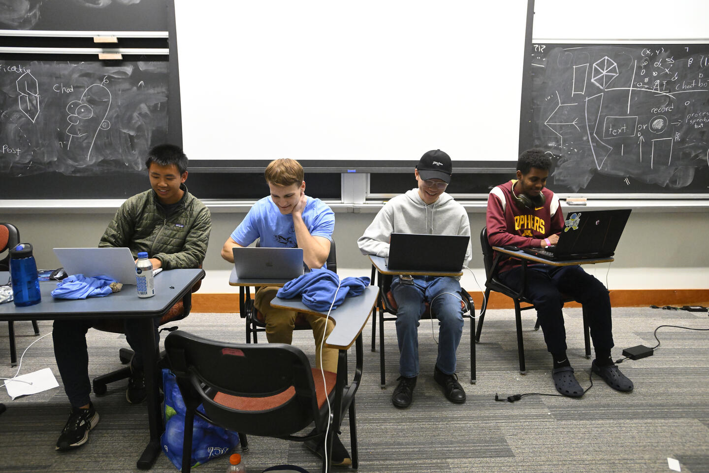 Students at a table working on laptops during HopHacks