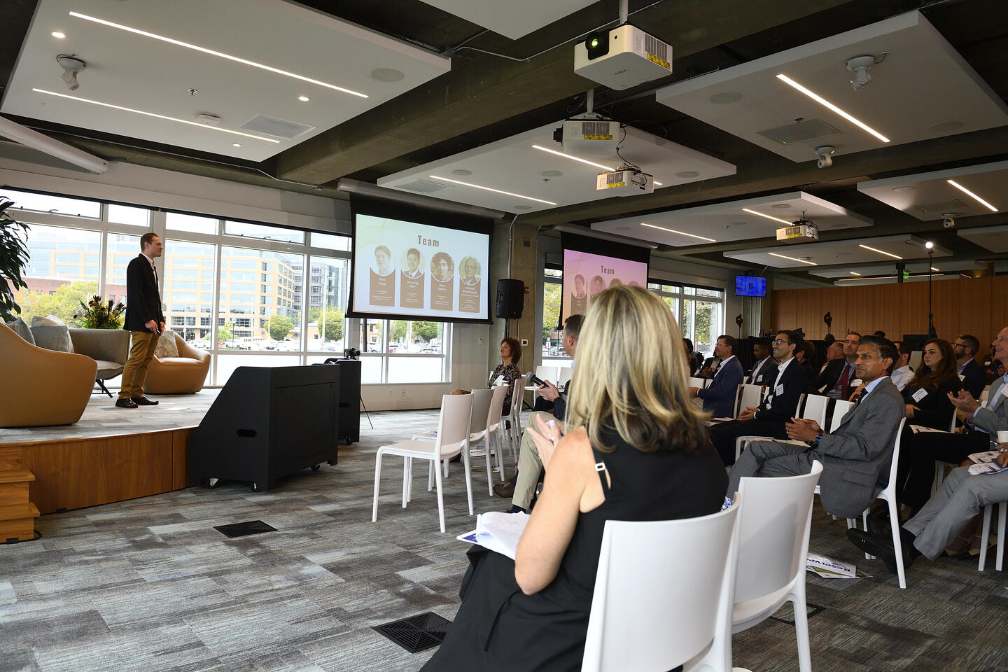 In a large conference room, people watch a man give a presentation at the Johns Hopkins Innovation Sumitt