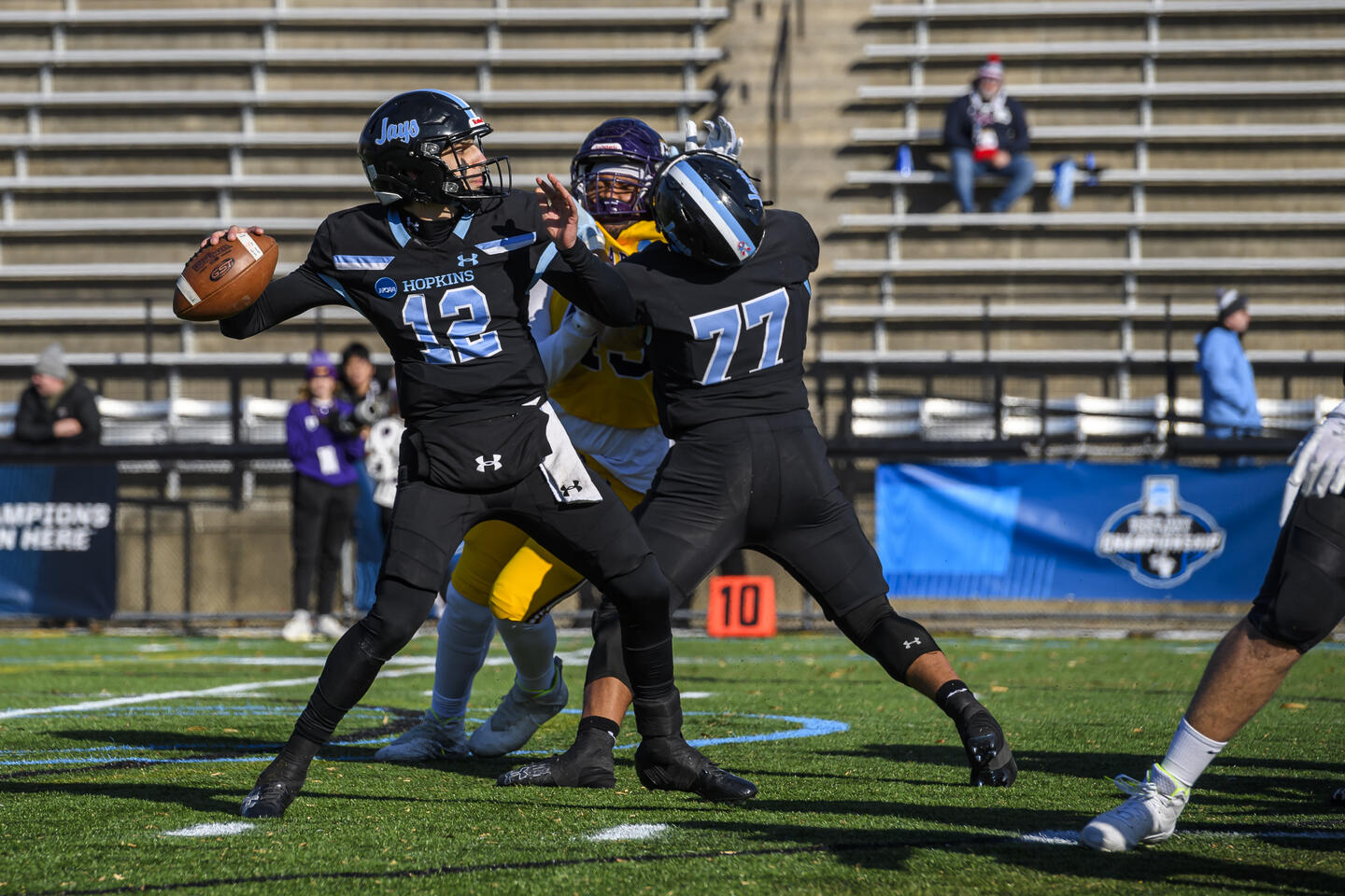 A Johns Hopkins football player winds up to throw the ball during a game.