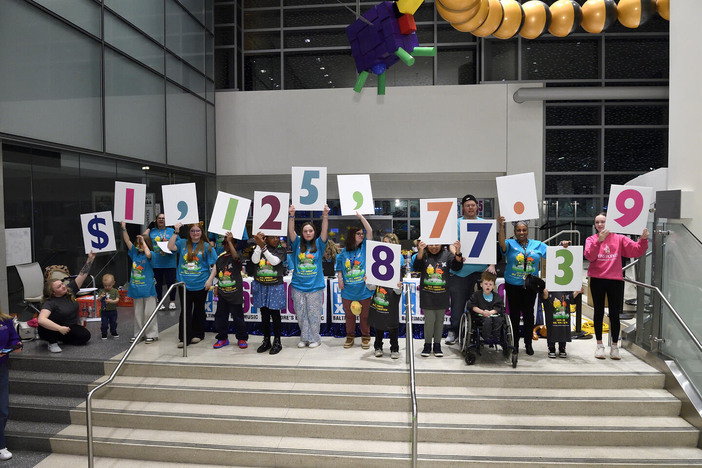 Children hold up number signs at radiothon