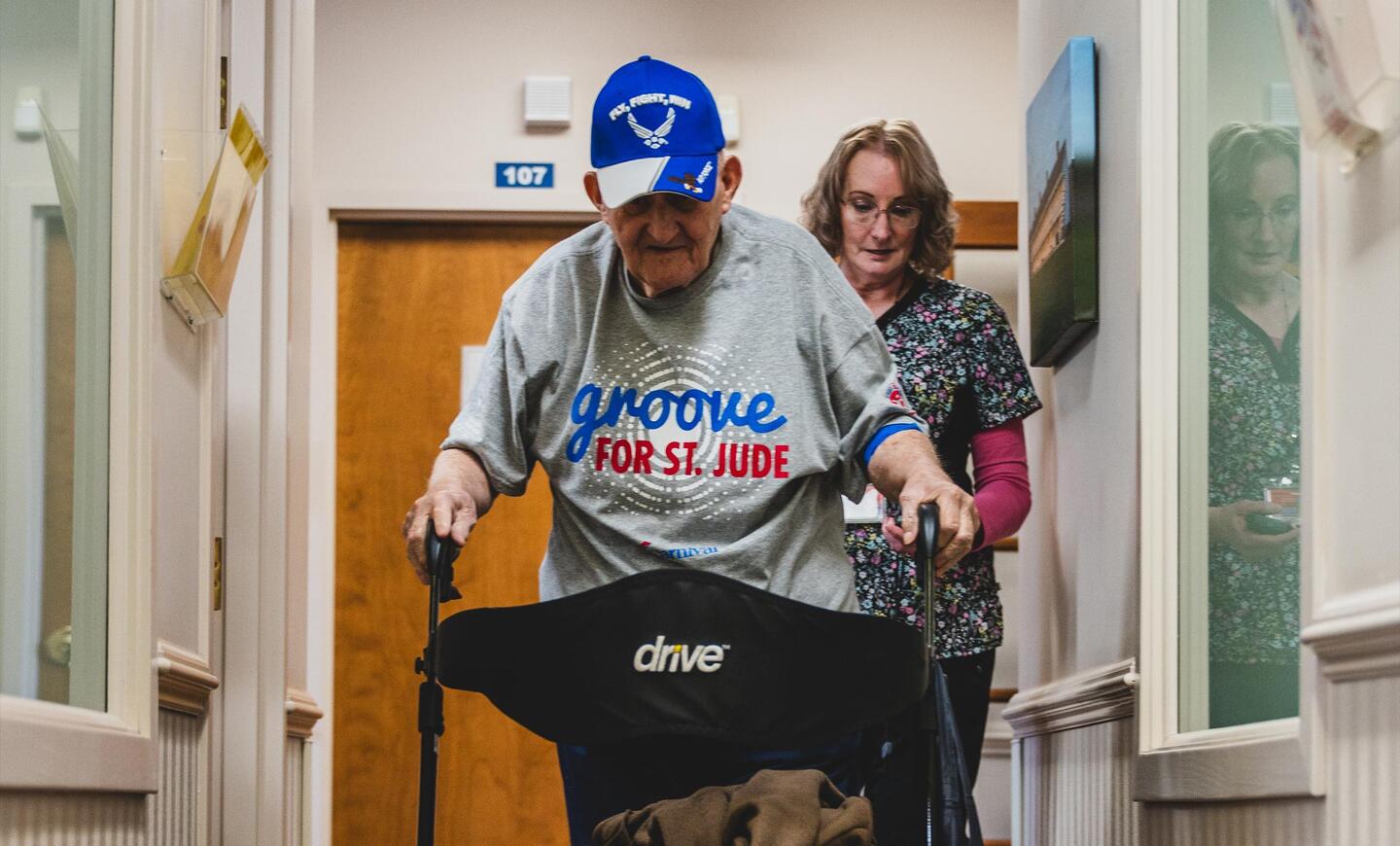 Frank Squibb uses his walker to make his way down one of the center's hallways