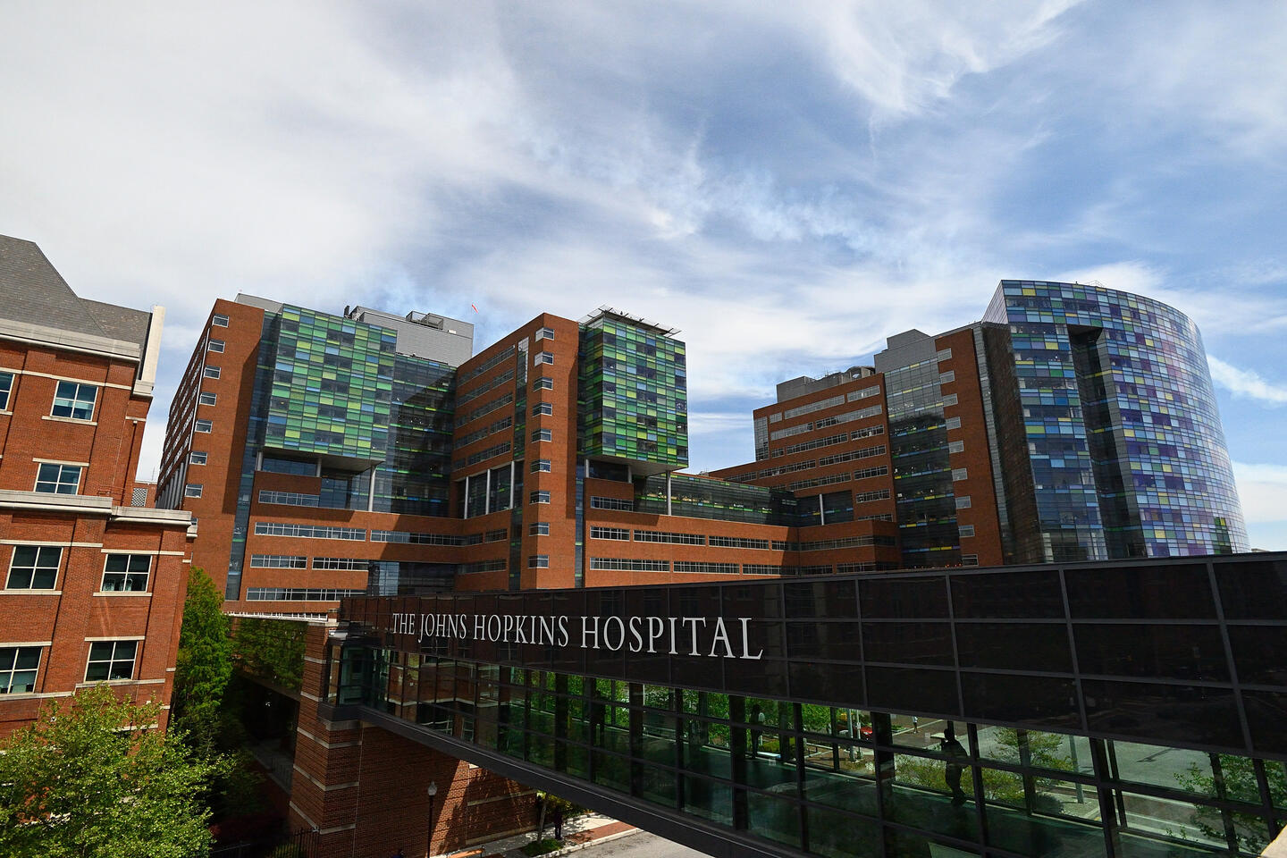 An exterior view of a hospital with a pedestrian walkway that ready Johns Hopkins Hospital