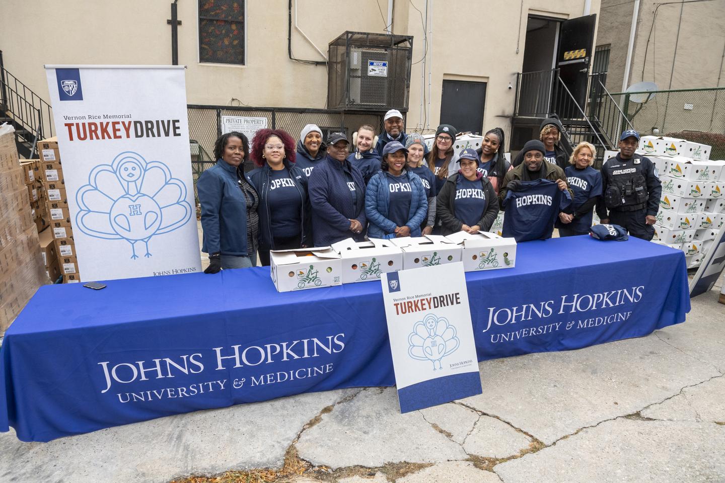 Hopkins volunteers pose by the turkey drive banner