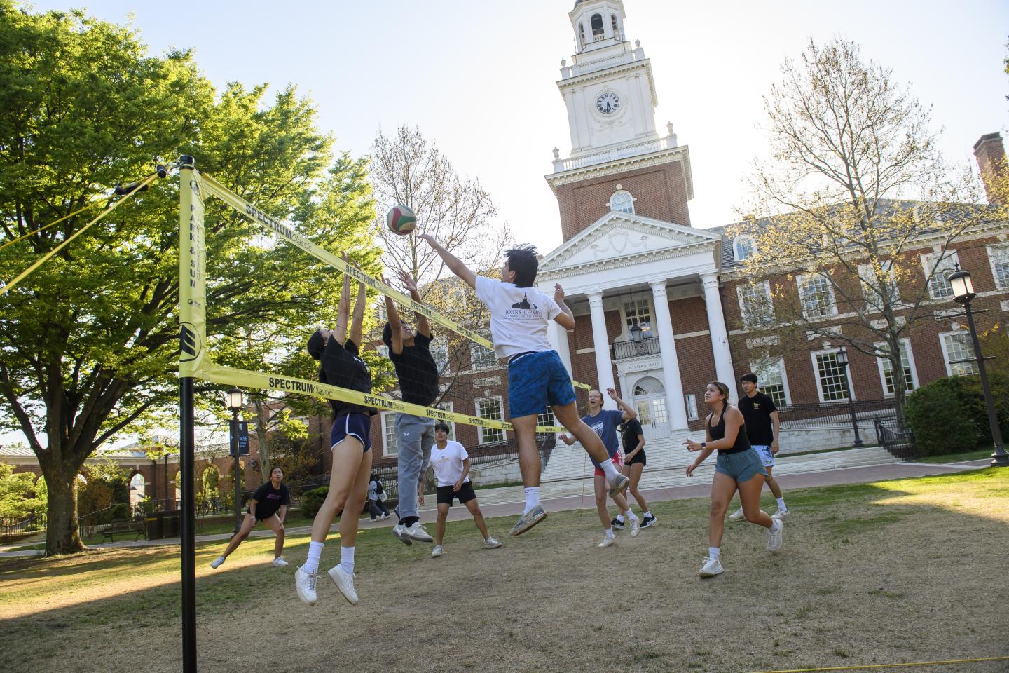 Students play volleyball on the quad in front of Gilman Hall.