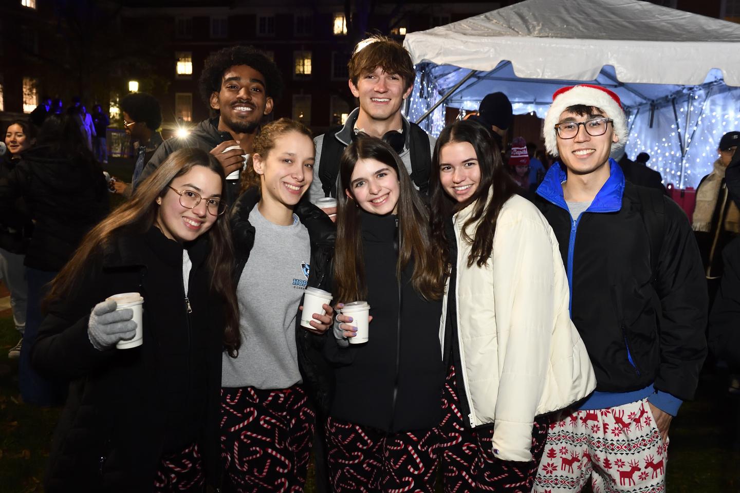 Seven college students pose for a group photo at Lighting of the Quads.