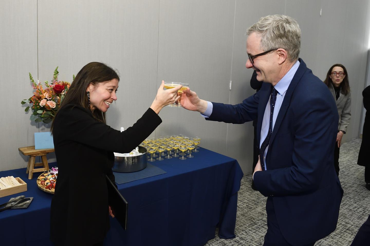 Two adults cheers glasses of sparkling cider.