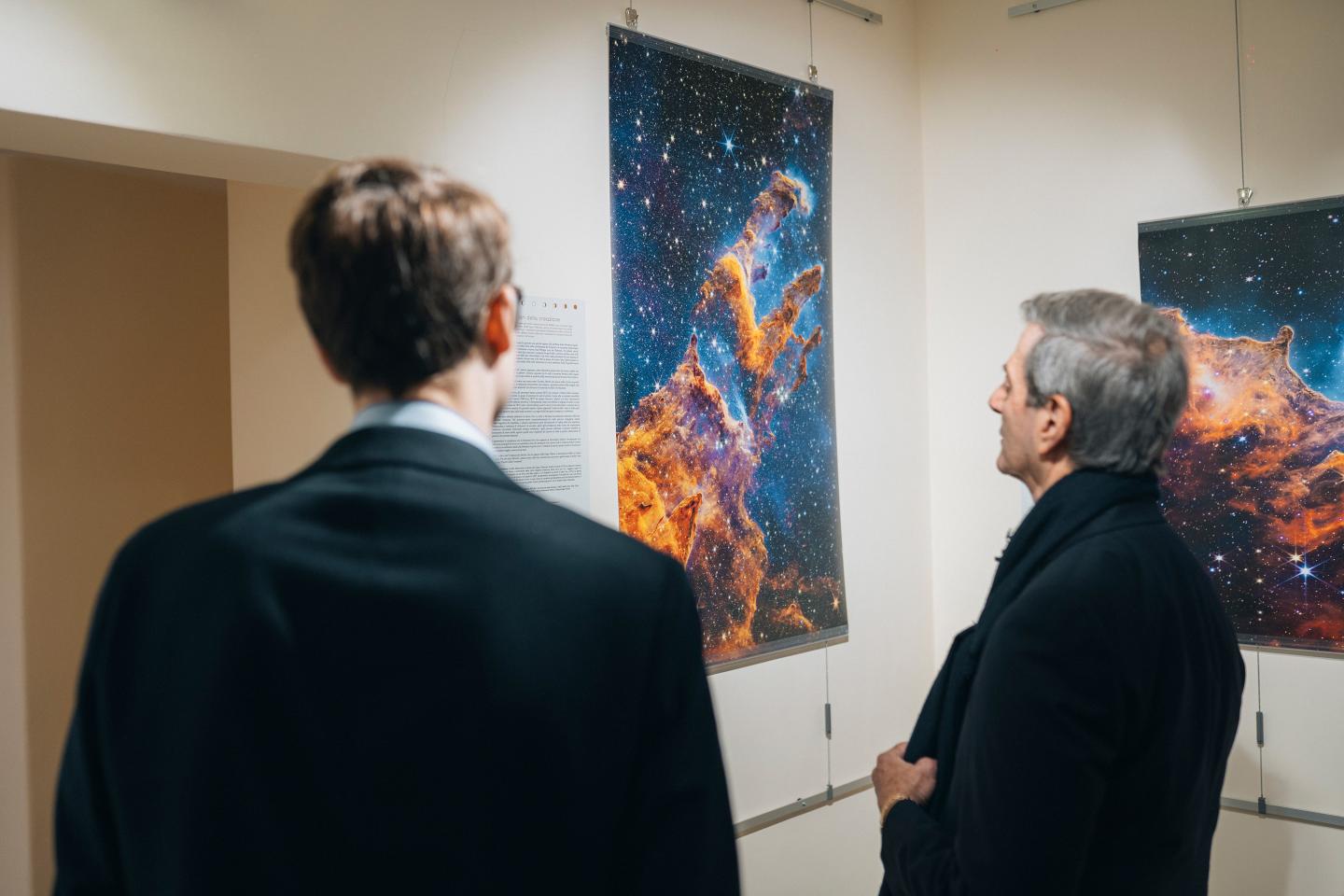 Two men look at a photo of the cosmos