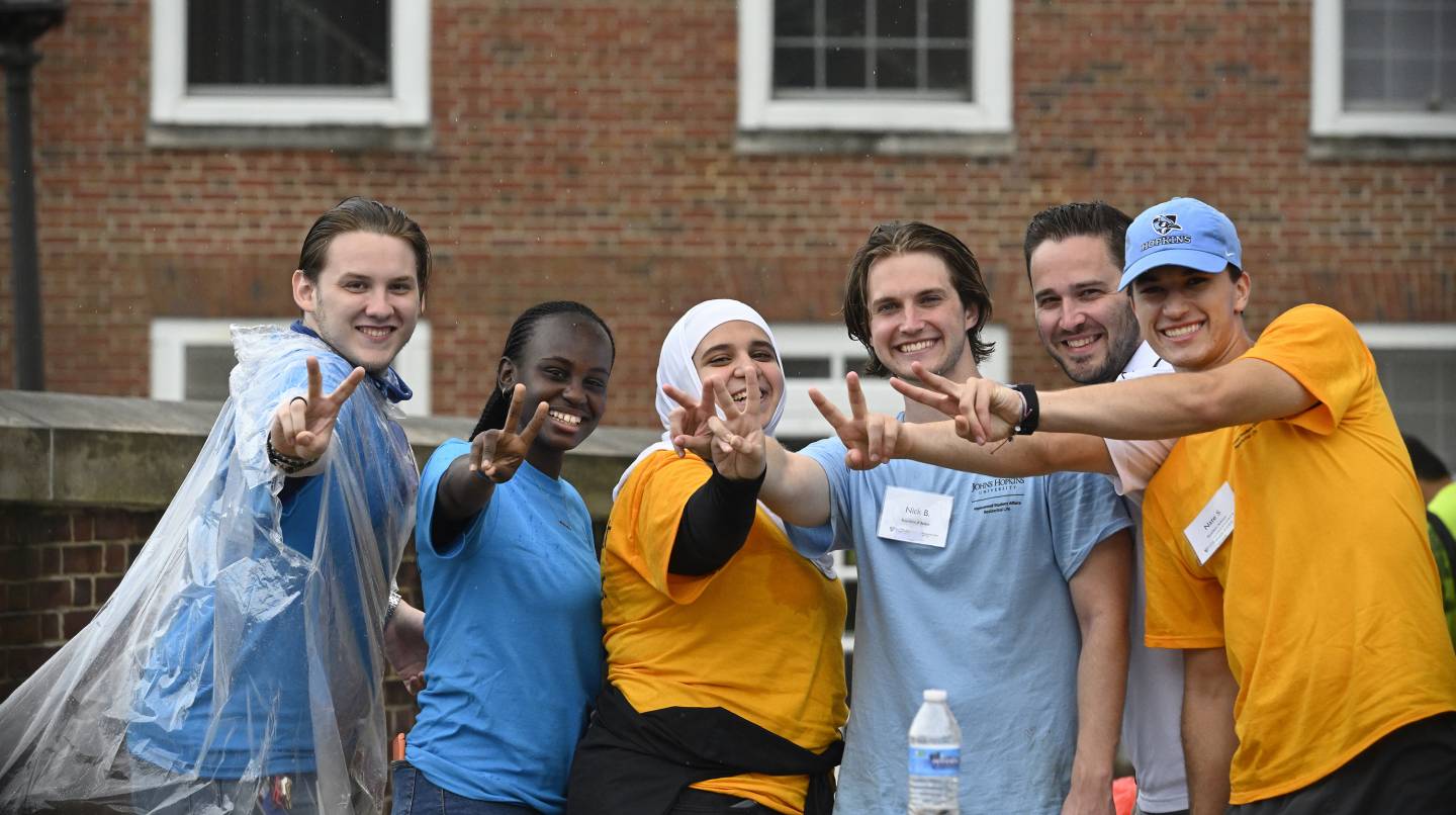 RAs give peace signs as they help new students move in