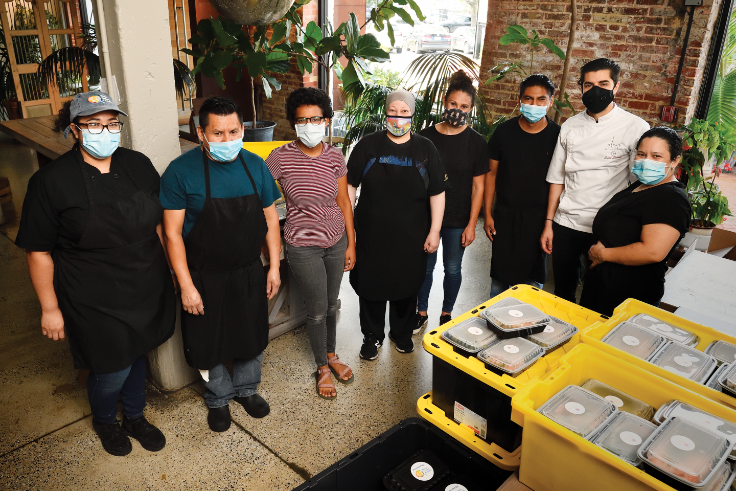 A group of masked people in a kitchen