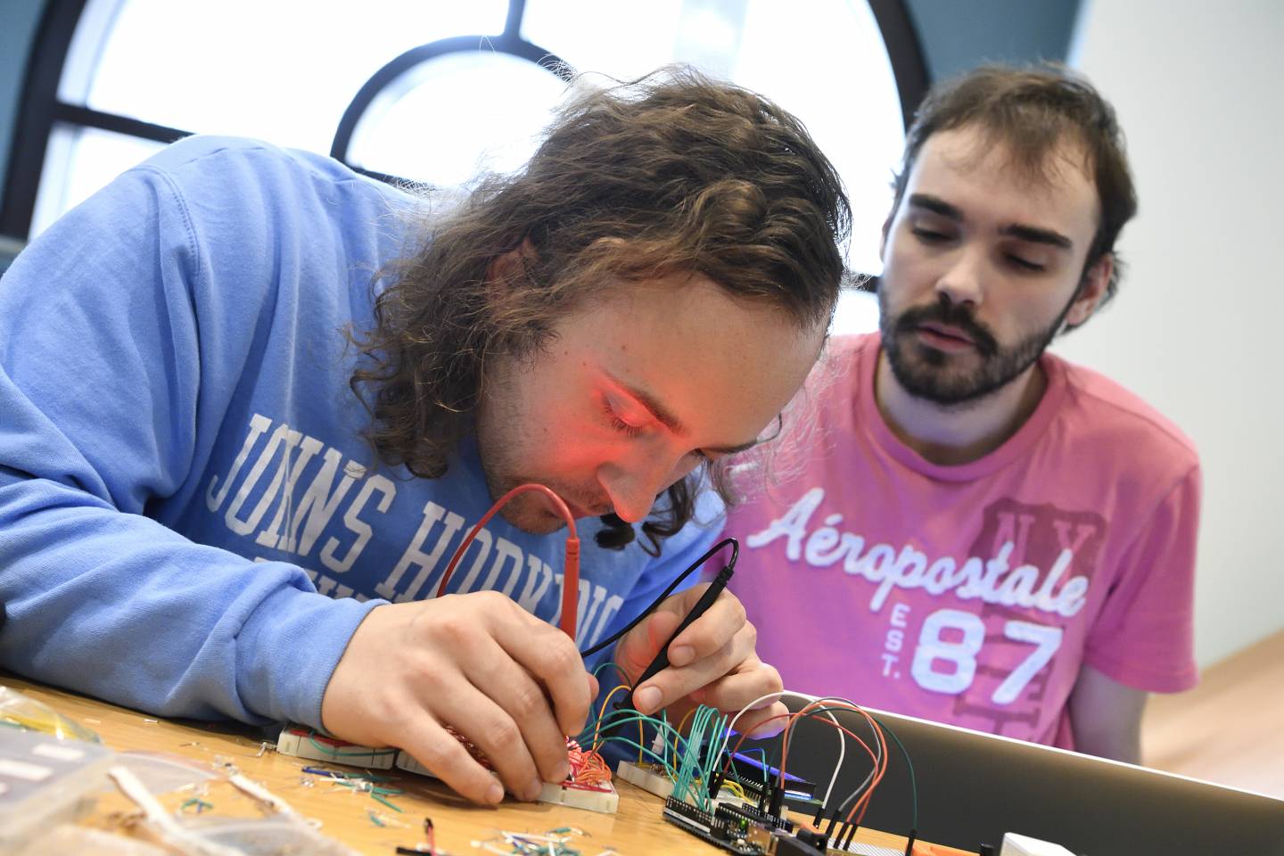 Two men build an electronic device