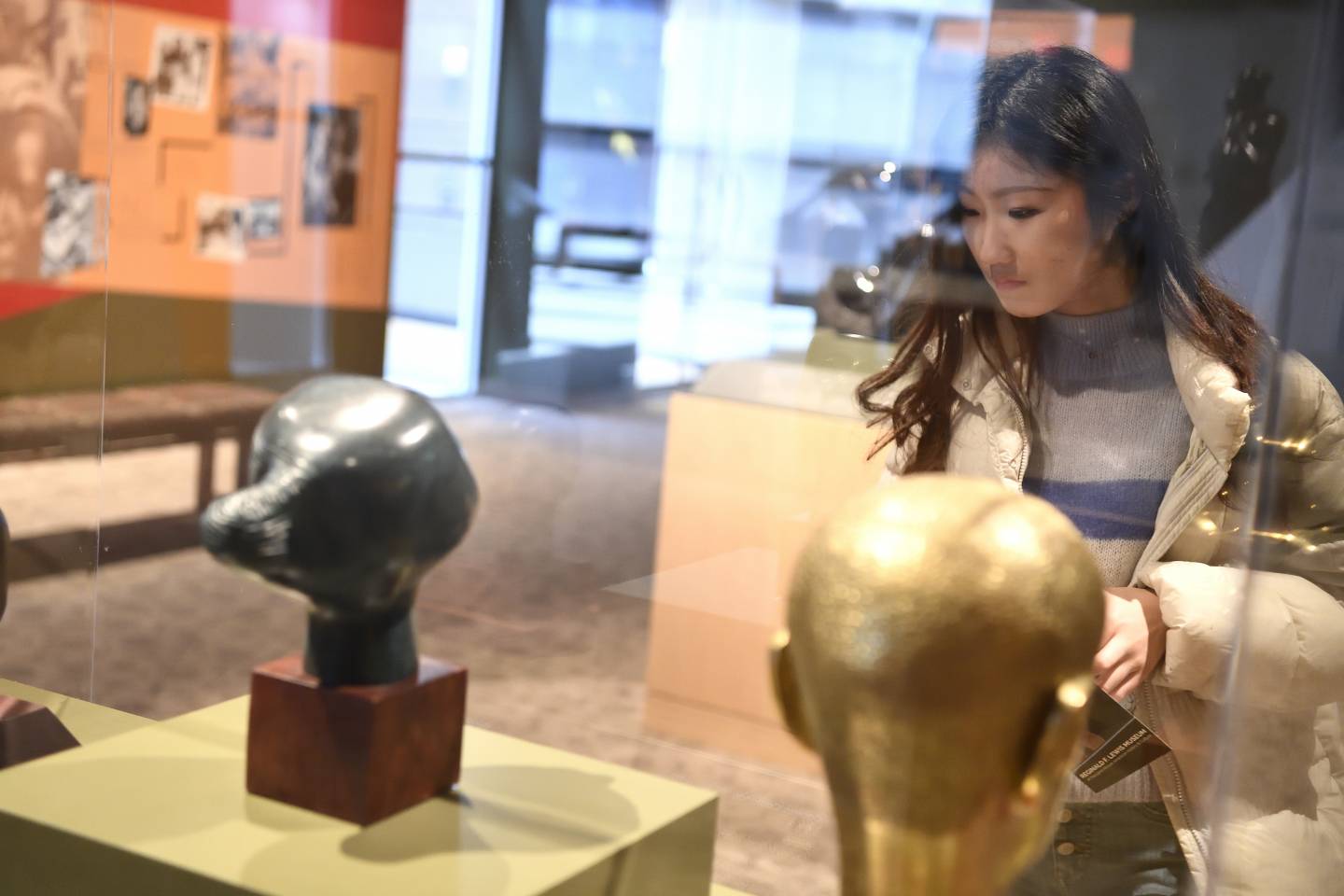 A woman examines an exhibit in a museum