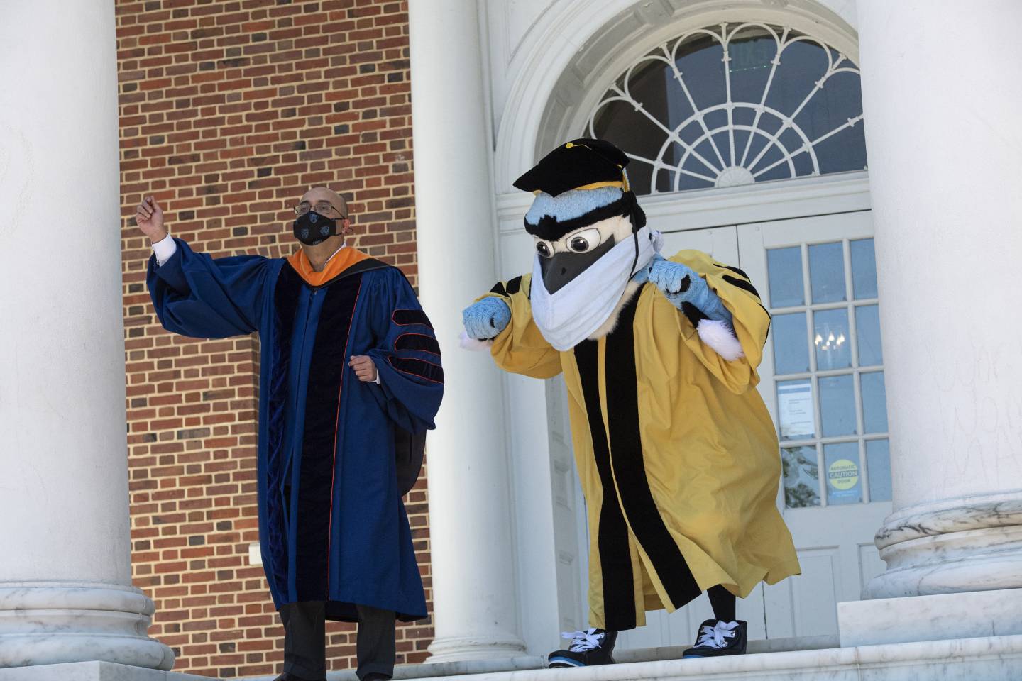 Blue Jay mascot and Provost Sunil Kumar dance on the steps of Gilman Hall