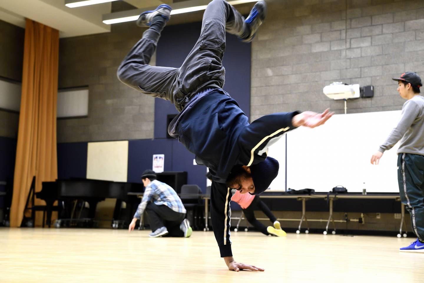 A breakdancer spins on his shoulders