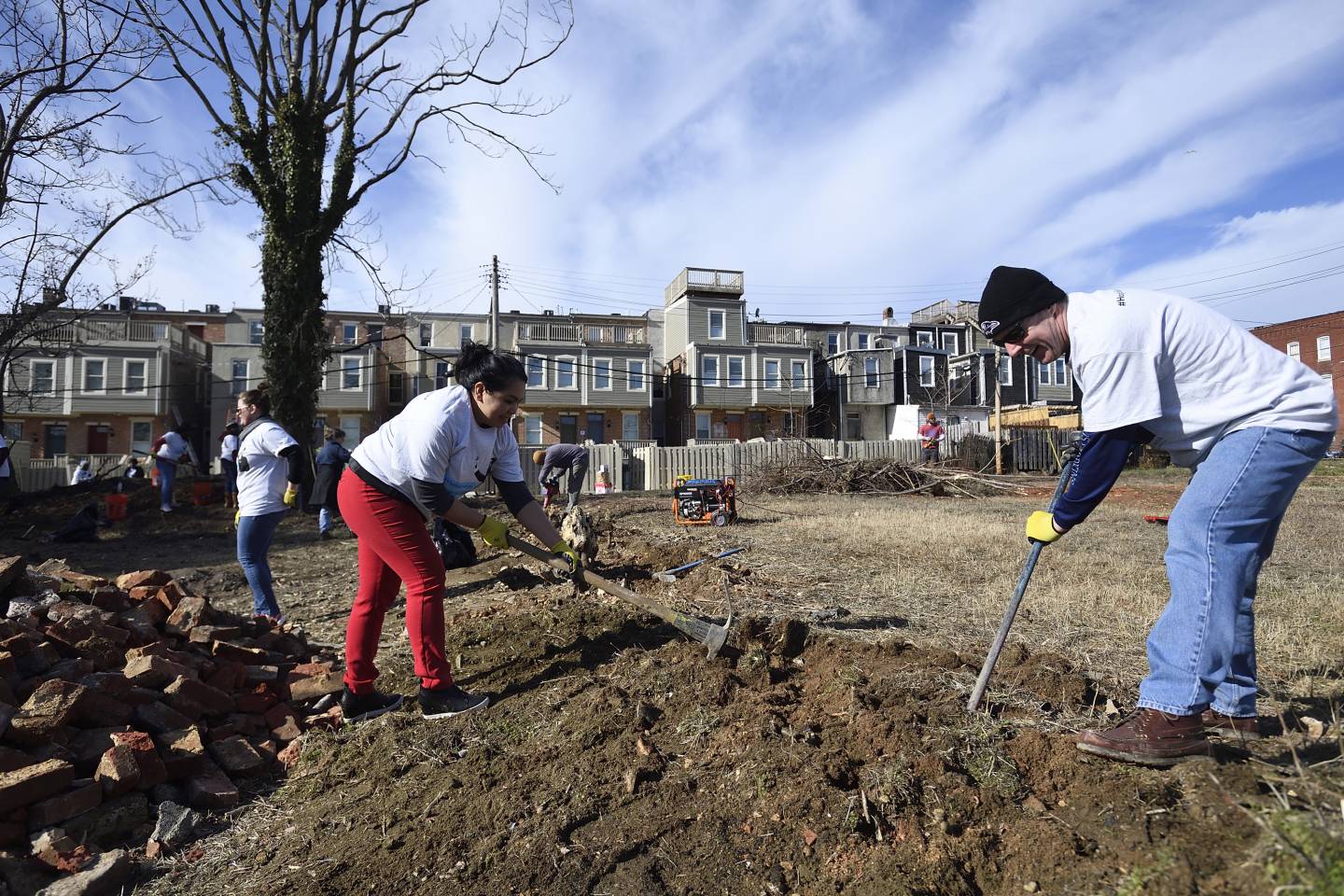 Volunteers shovel and ice pick ground in a vacant Baltimore lot