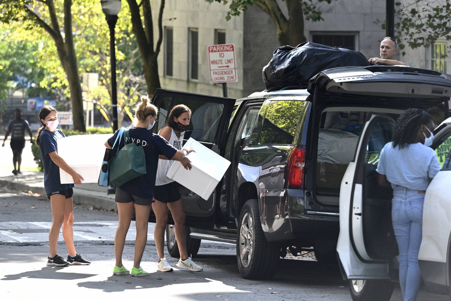Parents and siblings unload a car during move-in