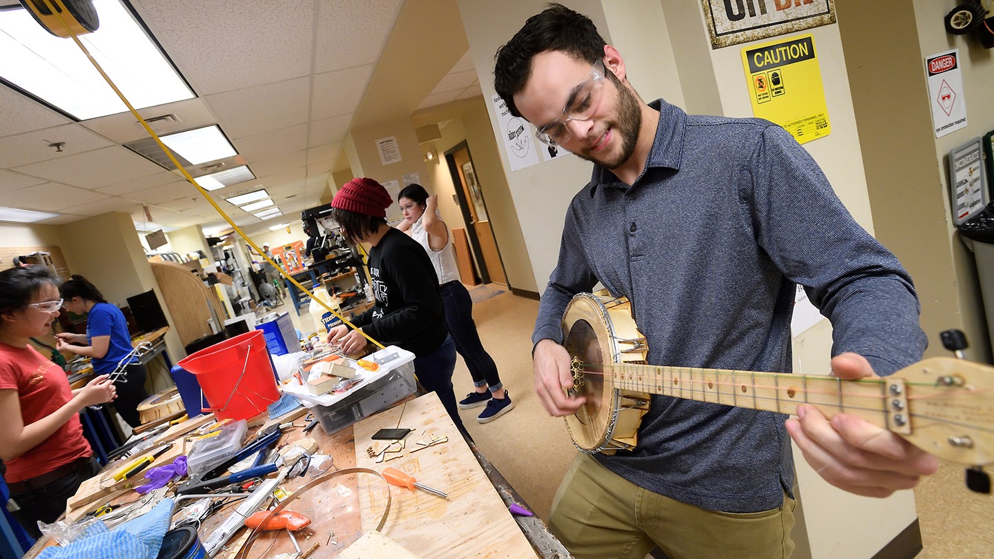 A student holds his banjo in the playing position