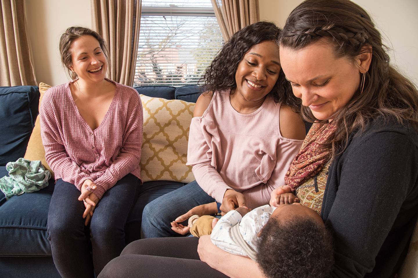 Doulas and a mother hold a baby