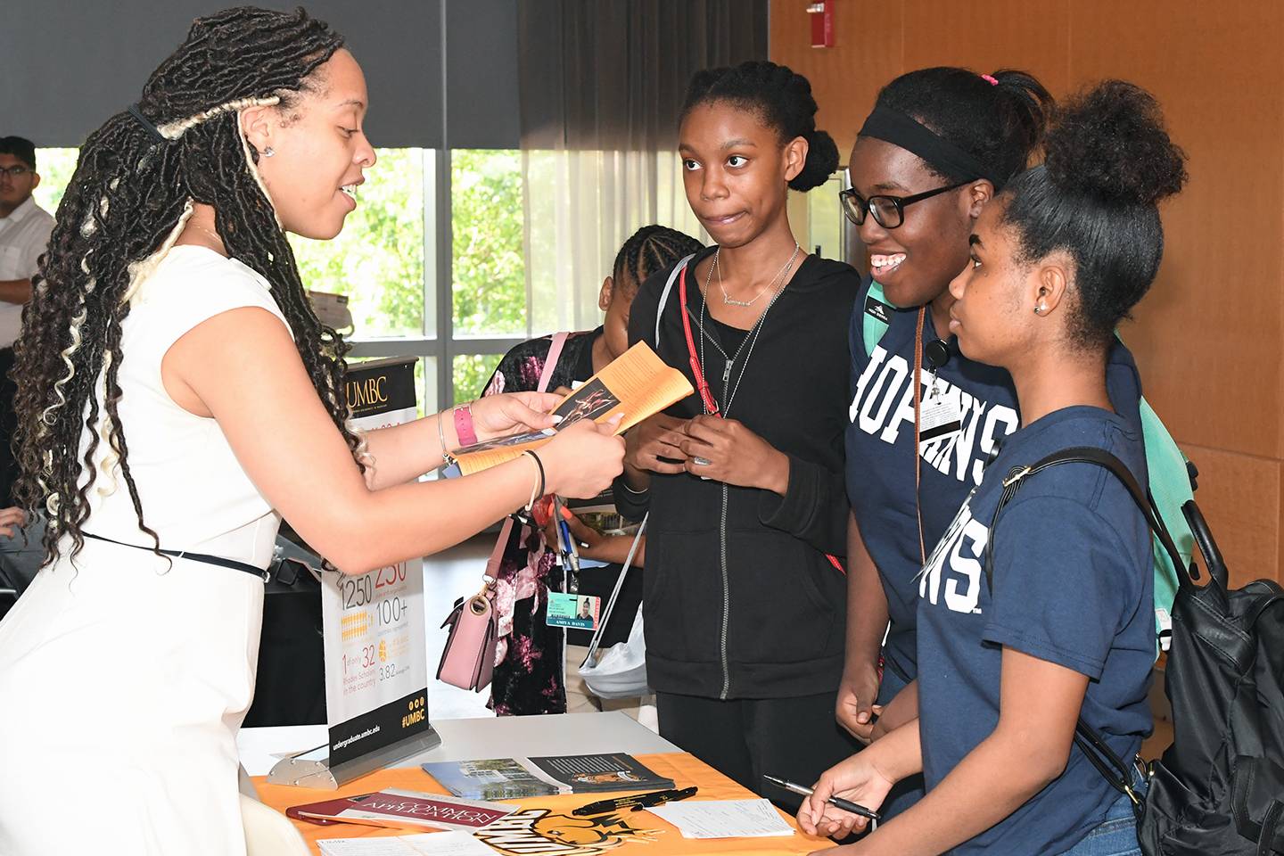 Students talk with a college rep at a college fair