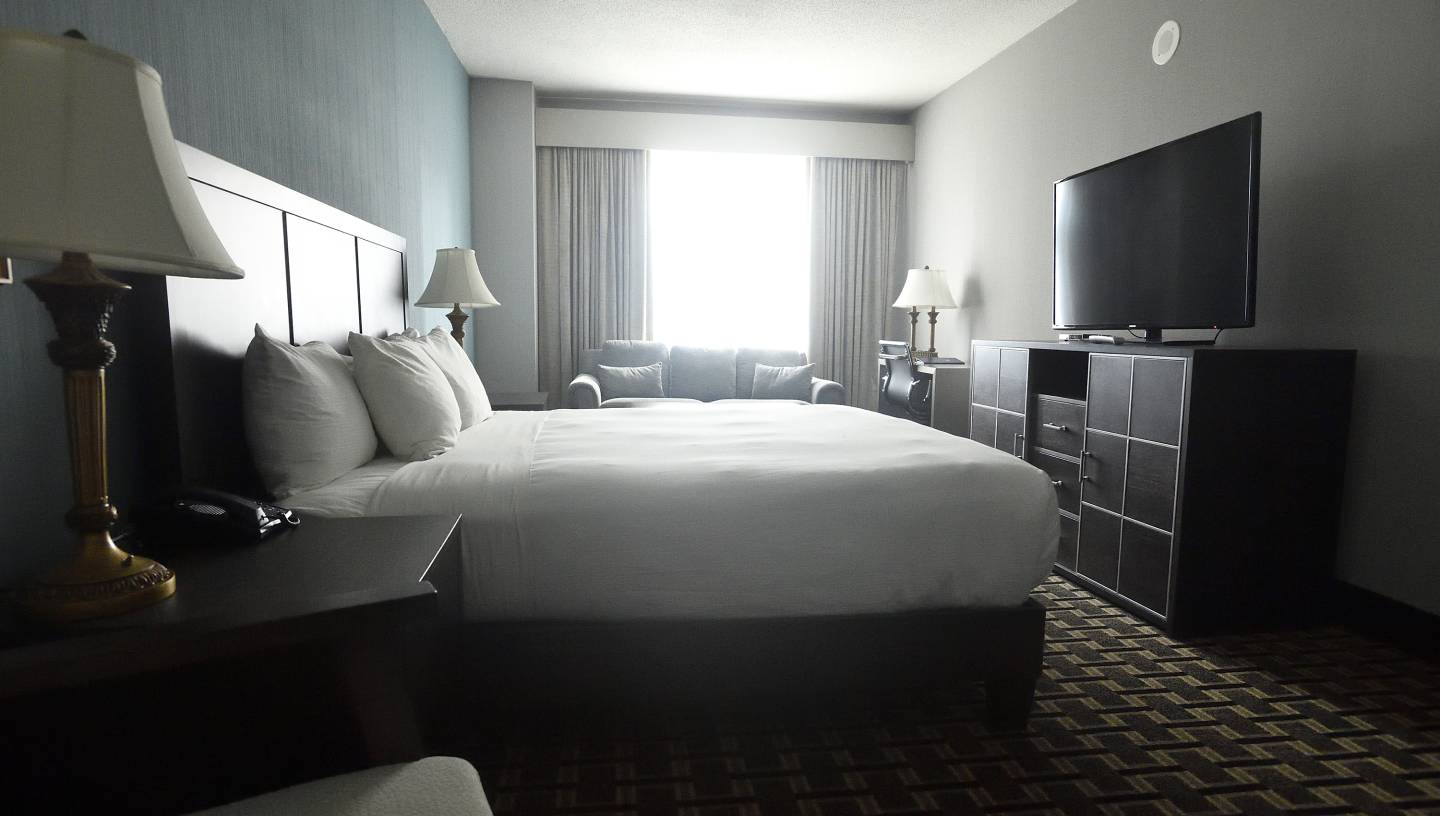 Rooms at the Colonnade include a bed, television, nightstand, and desk