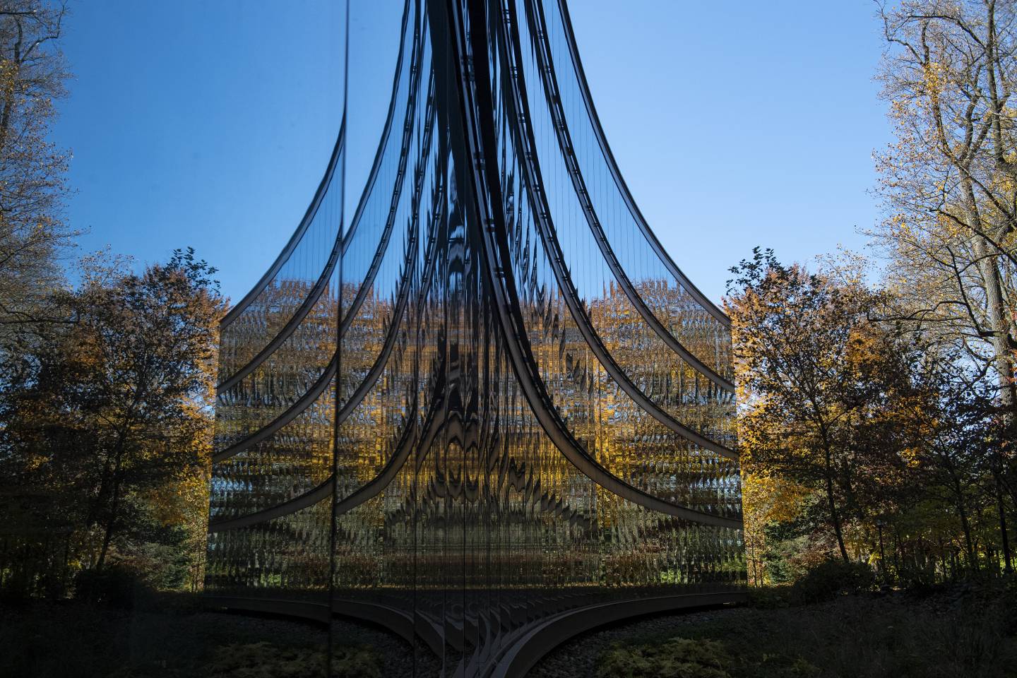 Autumn trees are reflected in the glass walls of the UTL