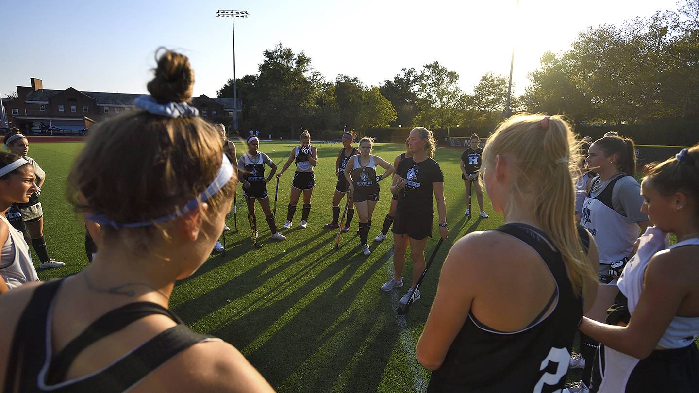 The field hockey team huddles up after practice