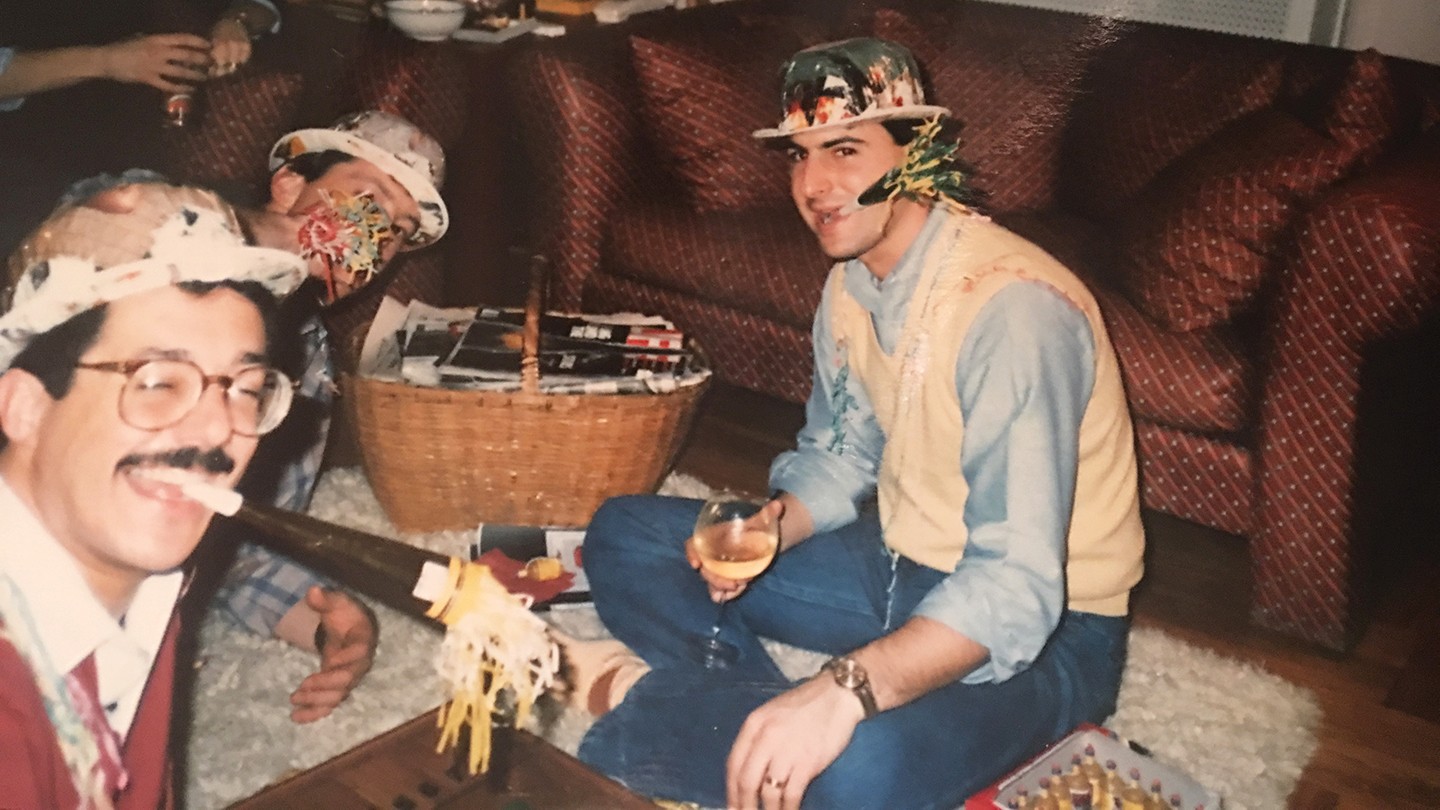Three men celebrate New Year's with noisemakers Three men celebrate New Year's with noisemakers