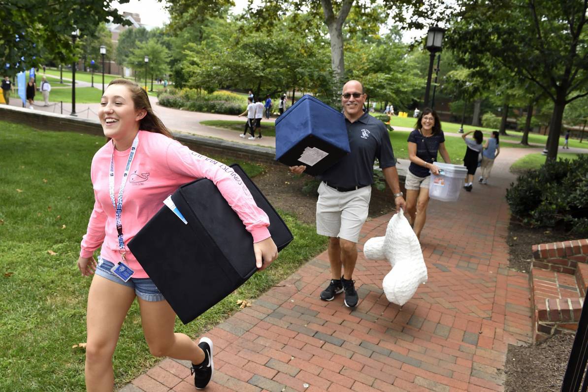 A student carries her belongings during move-in