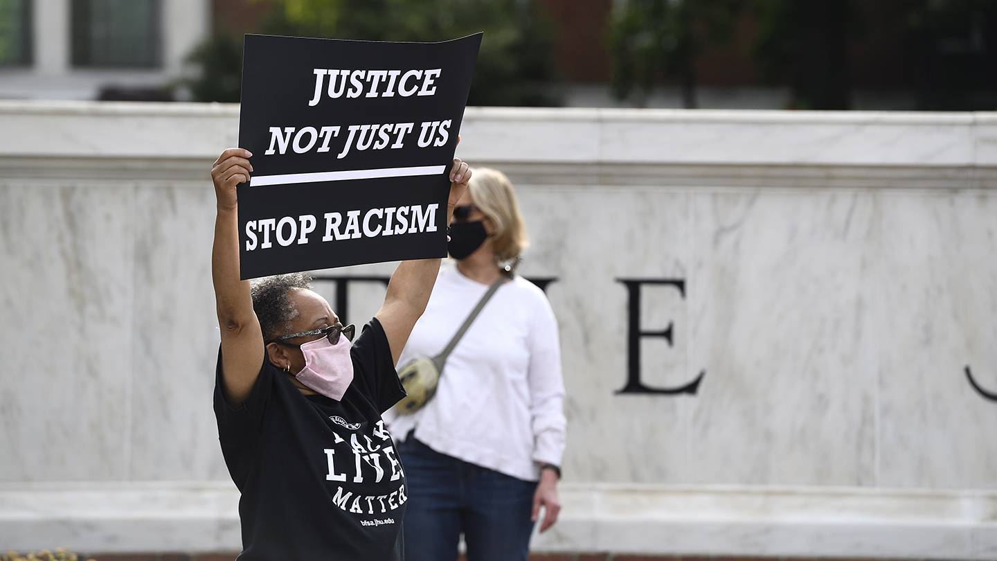 Protester holds sign reading 