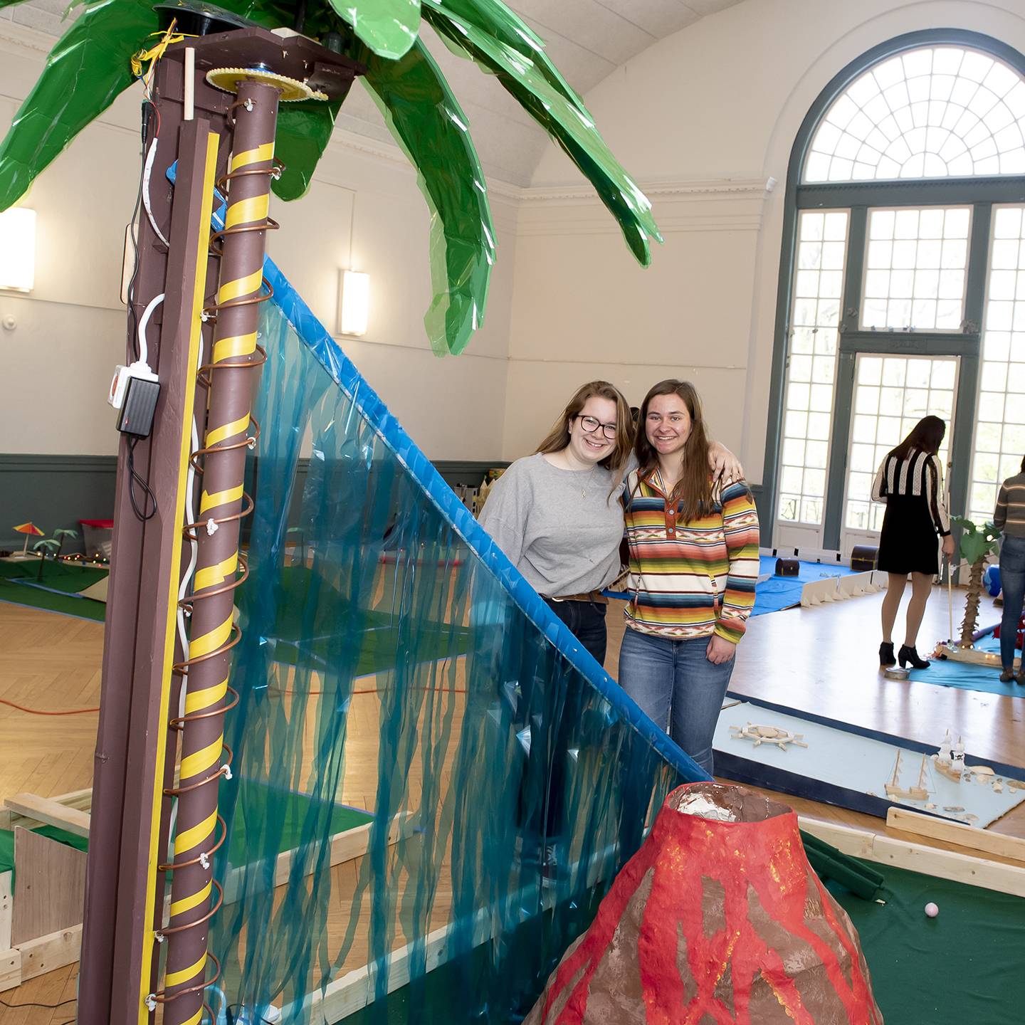 Designers stand beside the hole they designed for the mini golf course