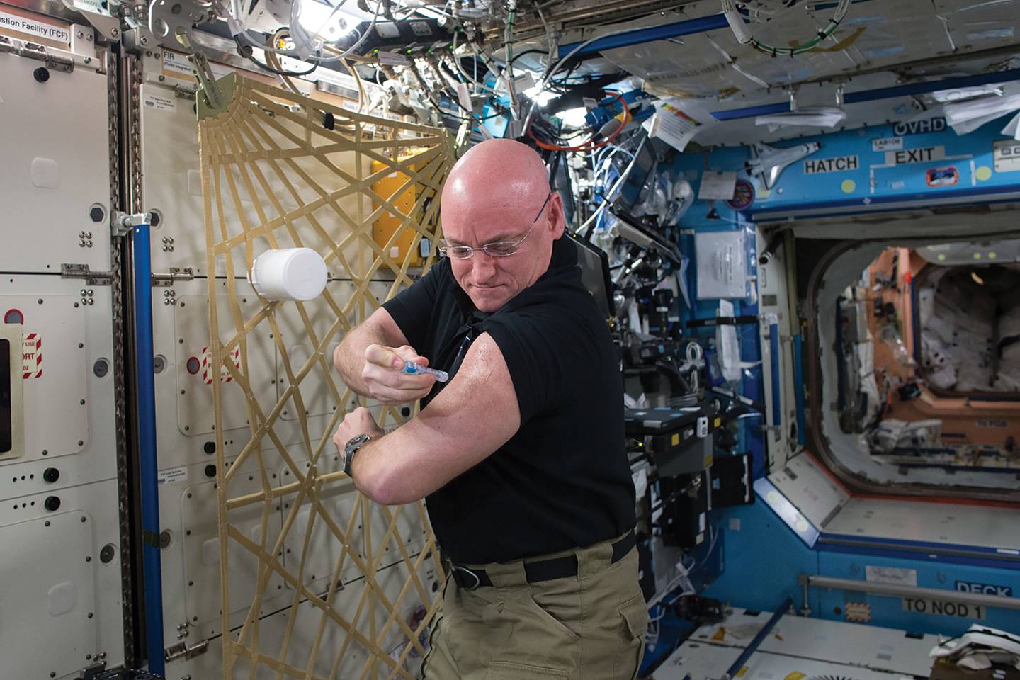 Astronaut Scott Kelly injects himself with a needle