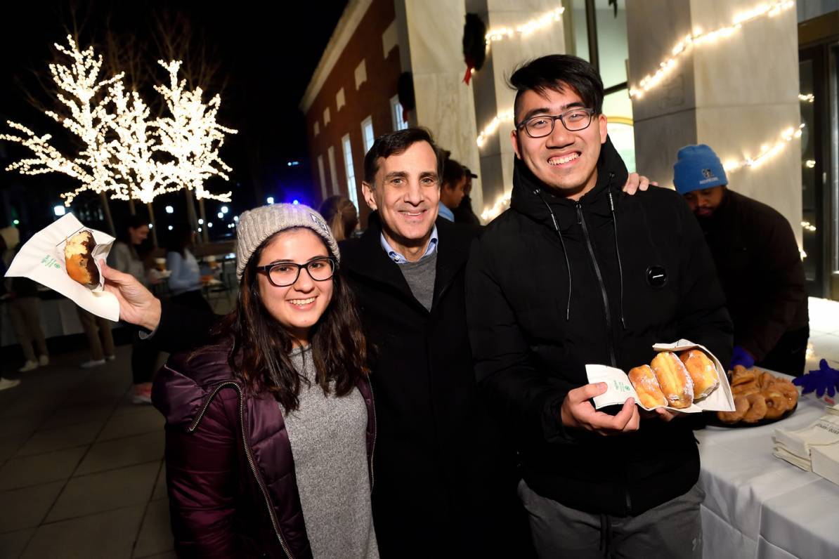 Student eat donuts with Daniels