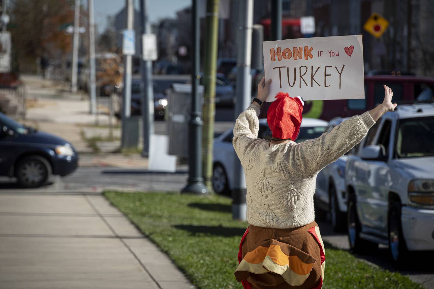 A woman in a turkey costume holds a sign reading 