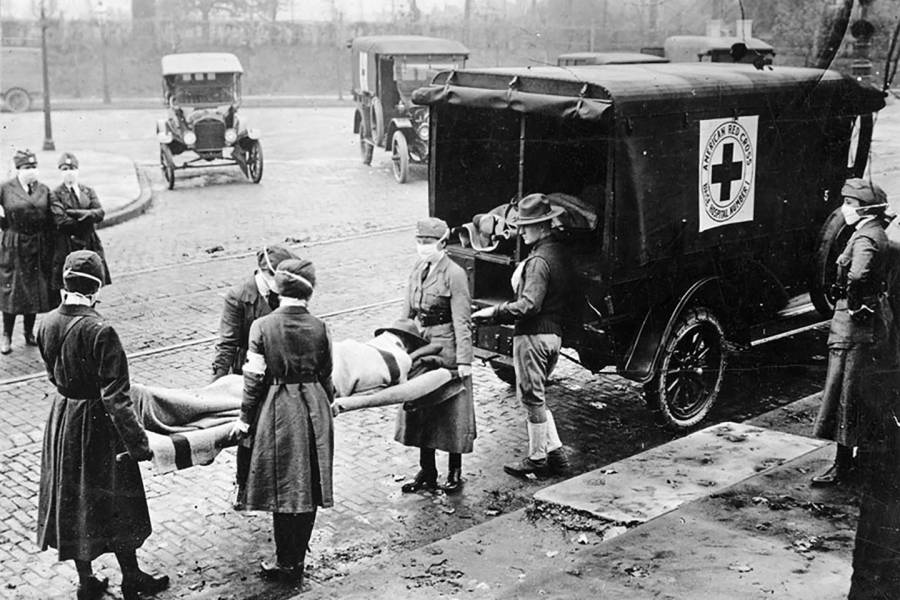 Nurses load a dead body into a Red Cross wagon during 1918 Spanish flu outbreak