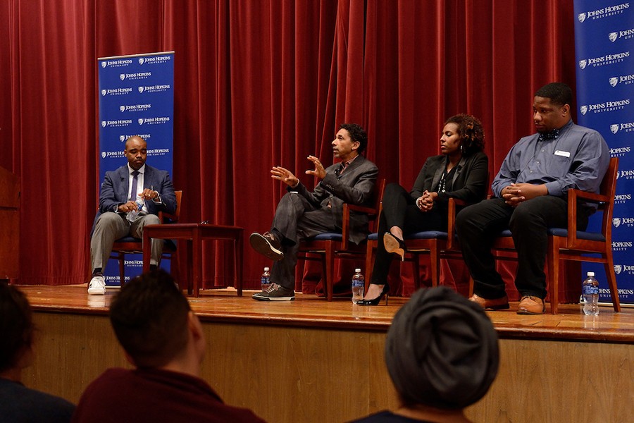 The JHU Forums on Race in America speakers sit onstage with a moderator. Robin Kelley speaks.
