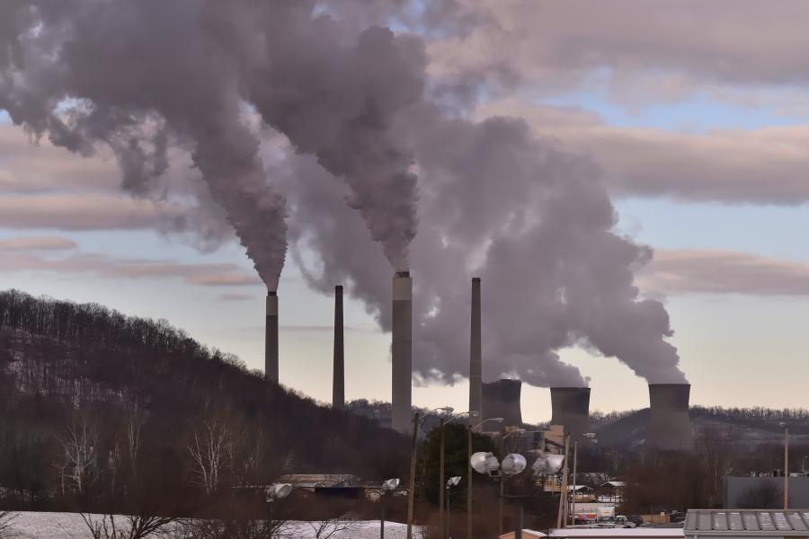 A coal-fired power plant with smoke rising from smokestacks