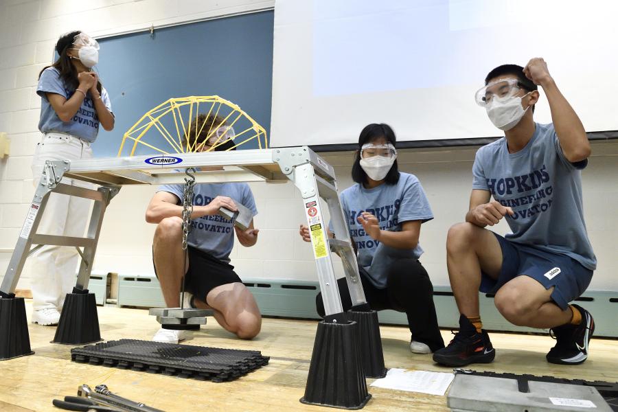 Students add weight to their spaghetti bridge