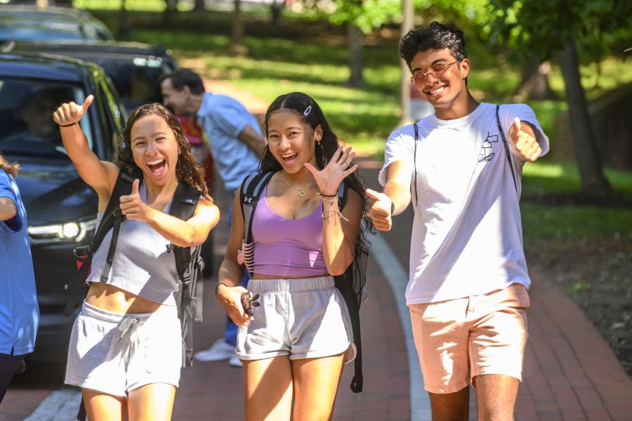 Students smile and give the thumbs up to the camera