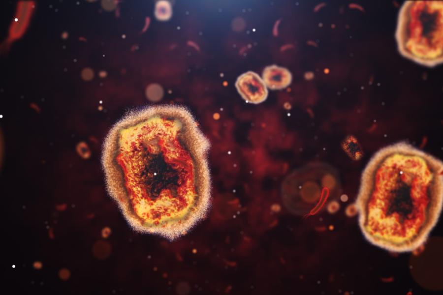 Orange monkeypox cells on a black background