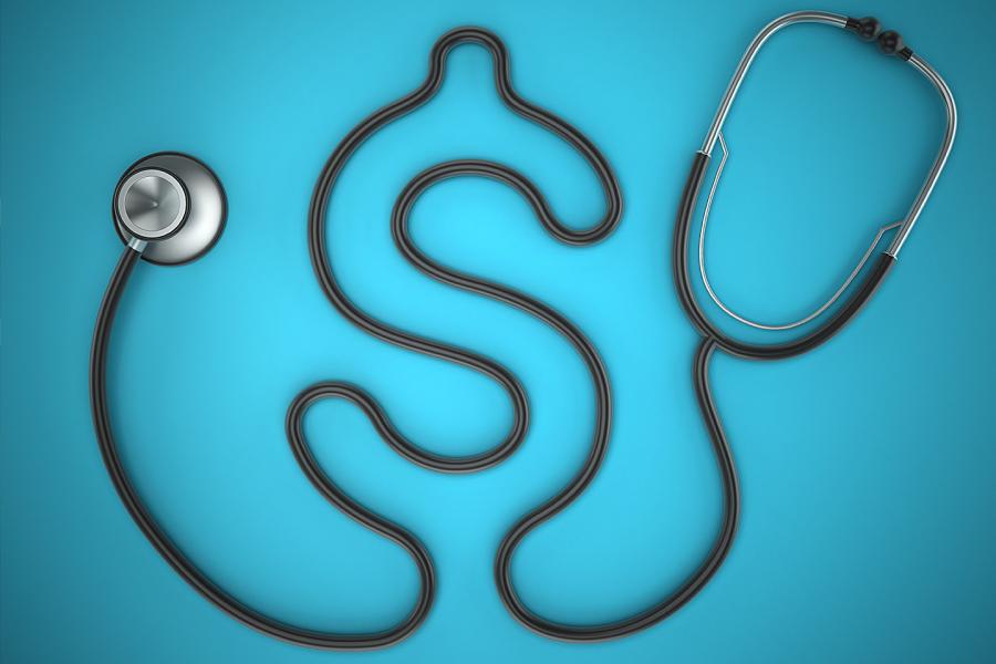 A black stethoscope whose tubing is laid out to create a dollar sign