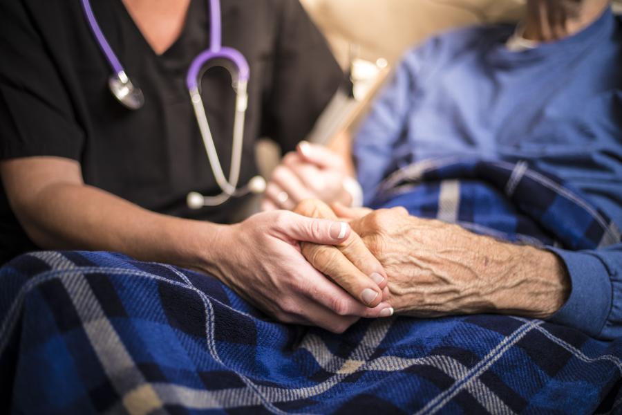 A health care worker works with an elderly patient