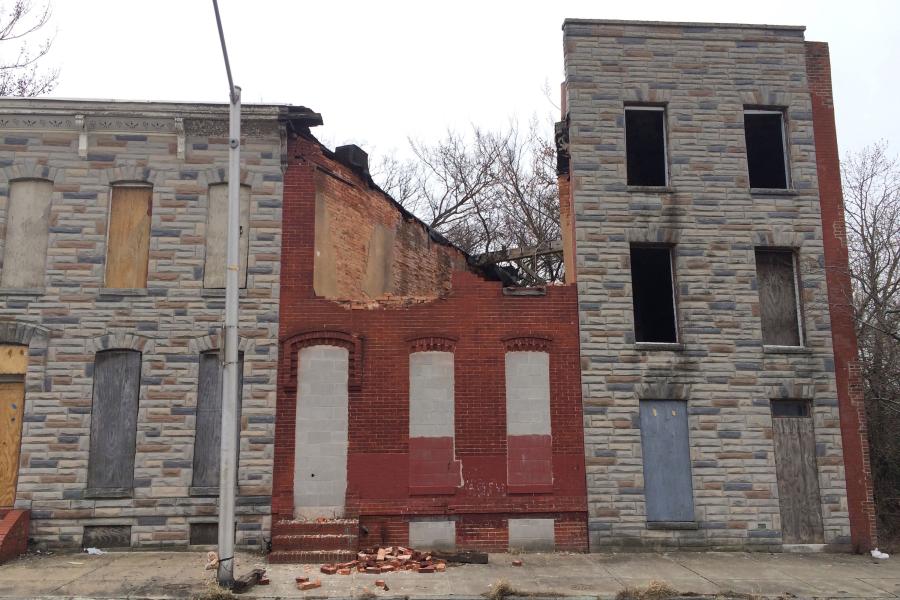 photo of crumbling, boarded up vacant houses in Baltimore